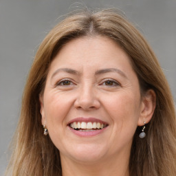 Joyful white adult female with long  brown hair and grey eyes