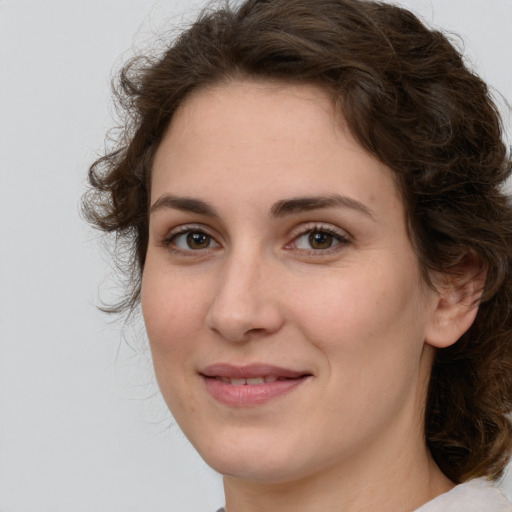 Joyful white young-adult female with medium  brown hair and green eyes