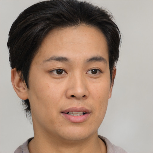 Joyful asian young-adult female with short  brown hair and brown eyes