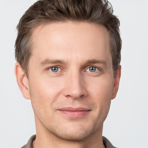 Joyful white young-adult male with short  brown hair and grey eyes