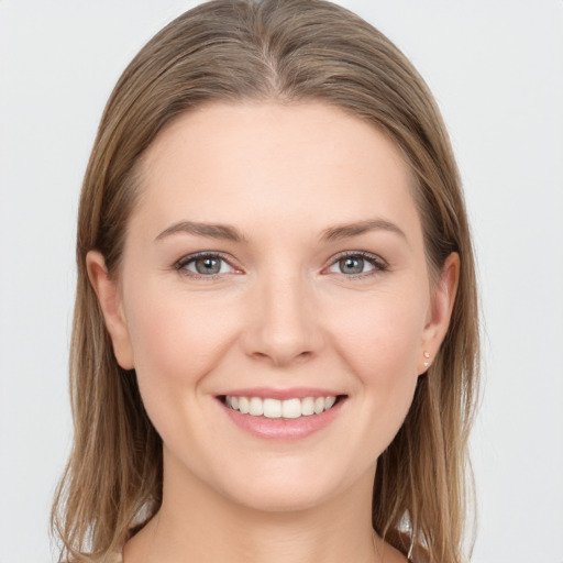 Joyful white young-adult female with medium  brown hair and grey eyes