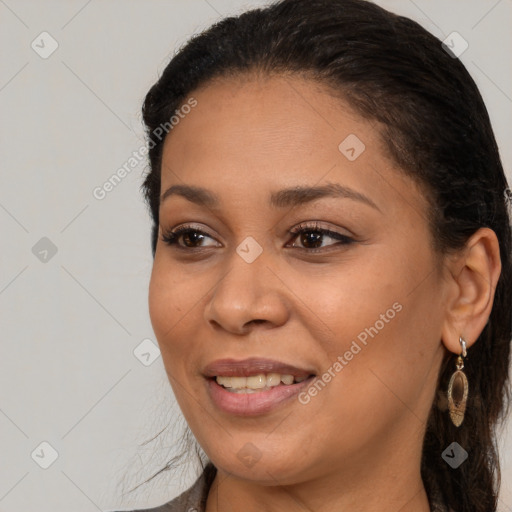 Joyful black young-adult female with long  brown hair and brown eyes