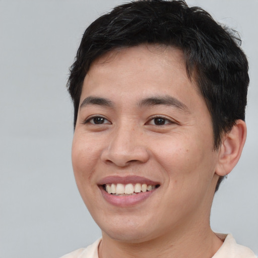 Joyful asian young-adult male with short  brown hair and brown eyes