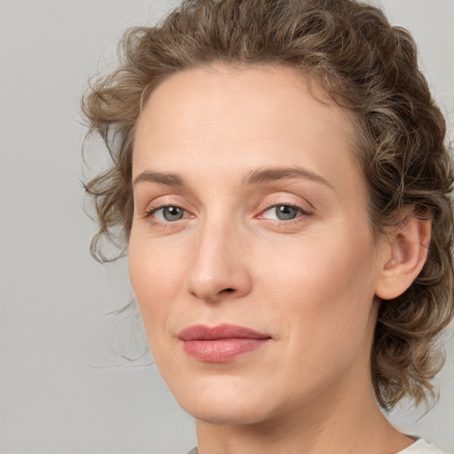 Joyful white young-adult female with medium  brown hair and green eyes