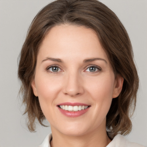 Joyful white young-adult female with medium  brown hair and grey eyes