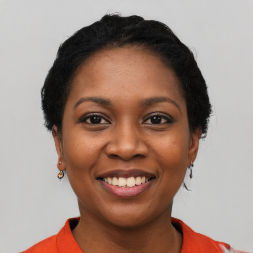 Joyful black young-adult female with short  black hair and brown eyes