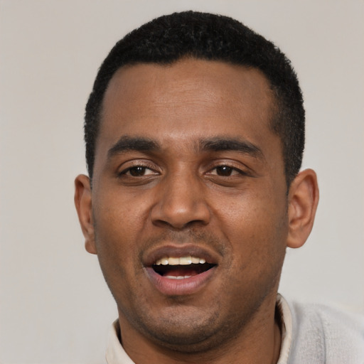 Joyful black young-adult male with short  black hair and brown eyes