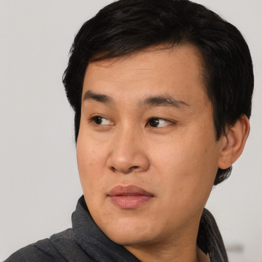 Joyful asian young-adult male with short  black hair and brown eyes