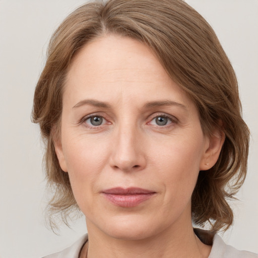 Joyful white adult female with medium  brown hair and grey eyes