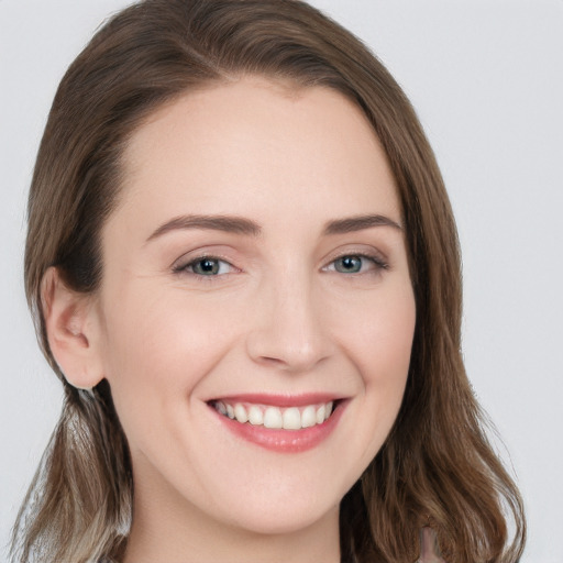 Joyful white young-adult female with long  brown hair and grey eyes