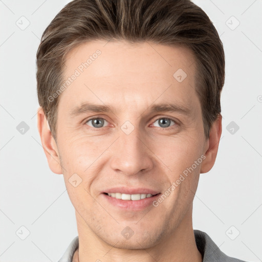 Joyful white young-adult male with short  brown hair and grey eyes