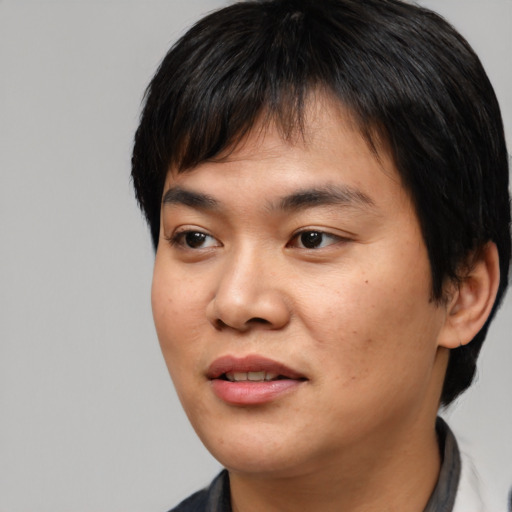 Joyful asian young-adult male with medium  black hair and brown eyes