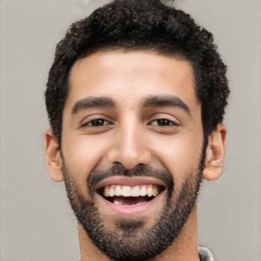 Joyful latino young-adult male with short  black hair and brown eyes