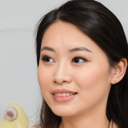 Joyful asian young-adult female with long  brown hair and brown eyes