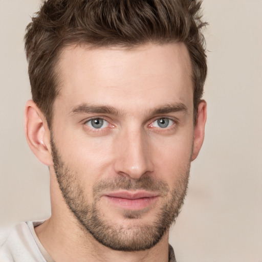 Joyful white young-adult male with short  brown hair and grey eyes