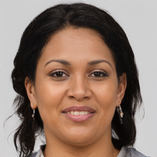 Joyful latino adult female with medium  brown hair and brown eyes