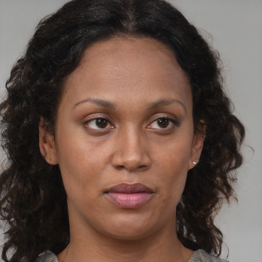 Joyful black adult female with medium  brown hair and brown eyes