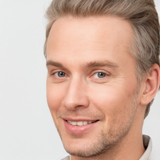 Joyful white adult male with short  brown hair and brown eyes