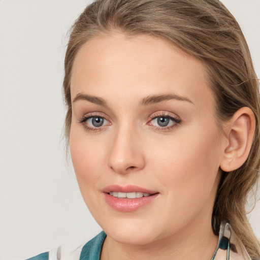 Joyful white young-adult female with long  brown hair and blue eyes