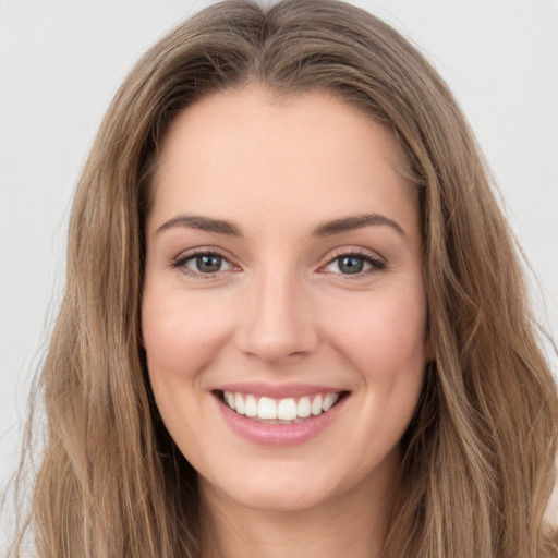 Joyful white young-adult female with long  brown hair and green eyes