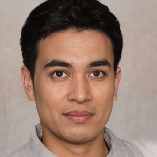 Joyful white young-adult male with short  black hair and brown eyes
