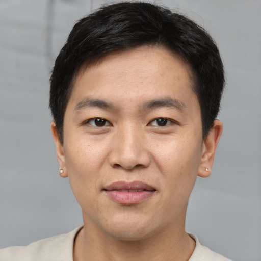 Joyful asian young-adult male with short  black hair and brown eyes