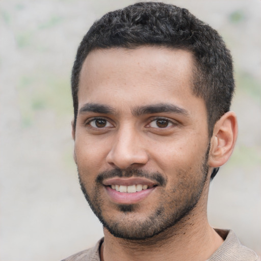 Joyful latino young-adult male with short  black hair and brown eyes