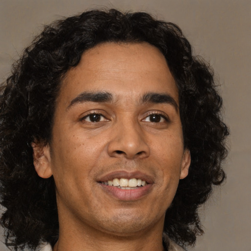 Joyful latino young-adult male with medium  brown hair and brown eyes