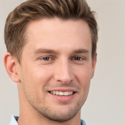 Joyful white young-adult male with short  brown hair and grey eyes