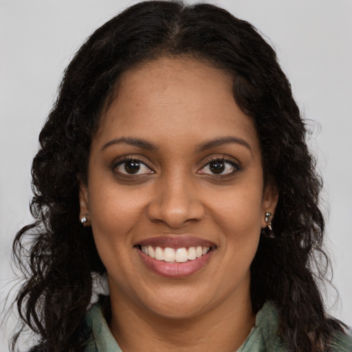 Joyful black young-adult female with long  brown hair and brown eyes