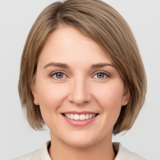 Joyful white young-adult female with medium  brown hair and grey eyes