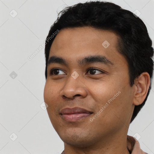 Joyful latino young-adult male with short  black hair and brown eyes