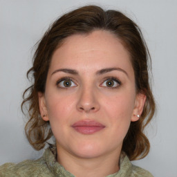 Joyful white young-adult female with medium  brown hair and green eyes