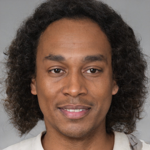 Joyful black adult male with medium  brown hair and brown eyes