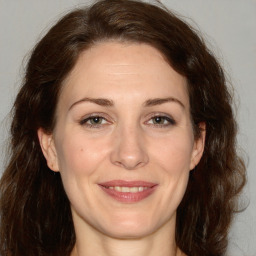 Joyful white adult female with medium  brown hair and brown eyes