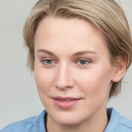 Joyful white young-adult female with medium  brown hair and blue eyes