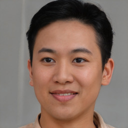 Joyful asian young-adult male with short  brown hair and brown eyes