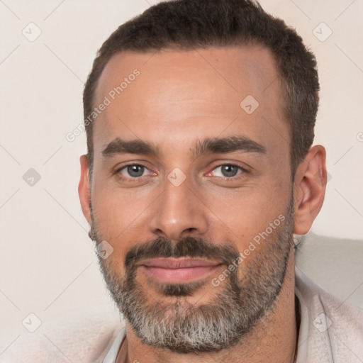 Joyful white adult male with short  black hair and brown eyes