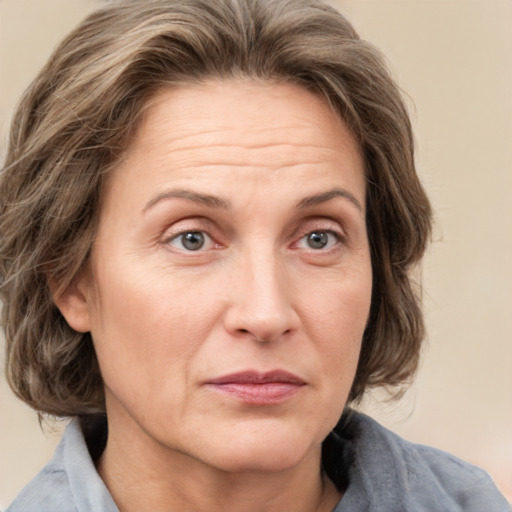 Joyful white adult female with medium  brown hair and grey eyes