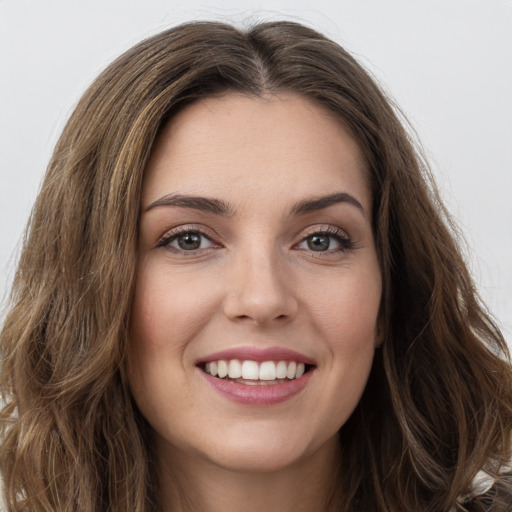 Joyful white young-adult female with long  brown hair and green eyes