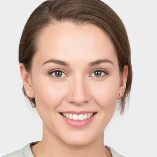 Joyful white young-adult female with medium  brown hair and grey eyes