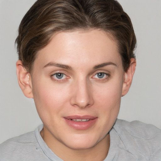 Joyful white young-adult female with short  brown hair and grey eyes