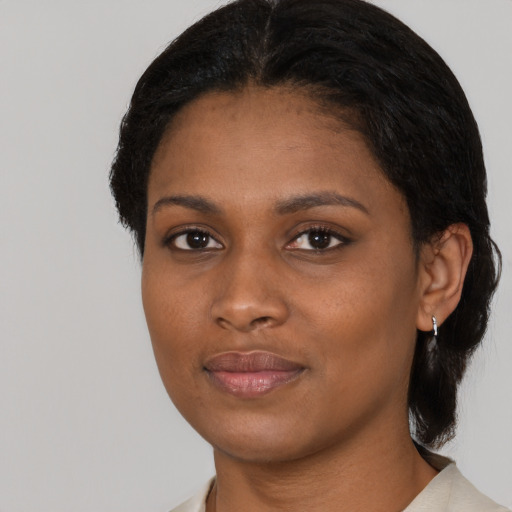 Joyful black young-adult female with short  black hair and brown eyes