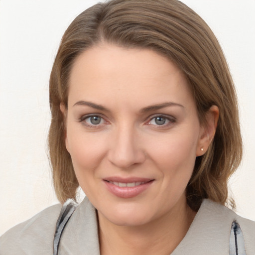 Joyful white young-adult female with medium  brown hair and grey eyes