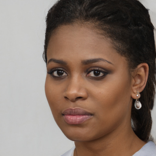 Joyful black young-adult female with long  brown hair and brown eyes