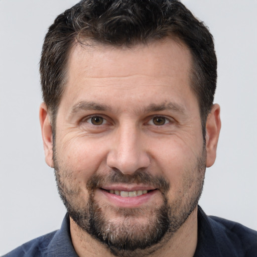 Joyful white adult male with short  brown hair and brown eyes