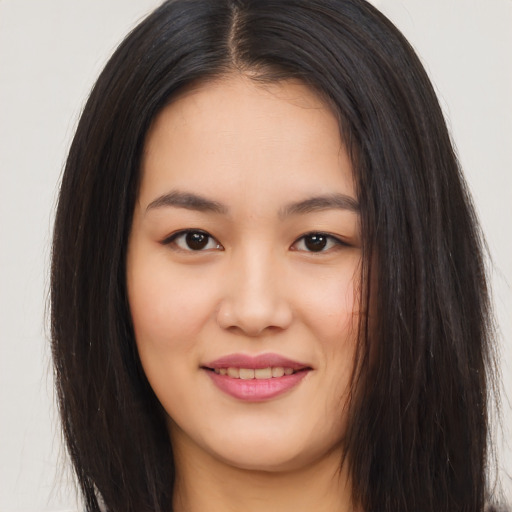 Joyful asian young-adult female with long  brown hair and brown eyes
