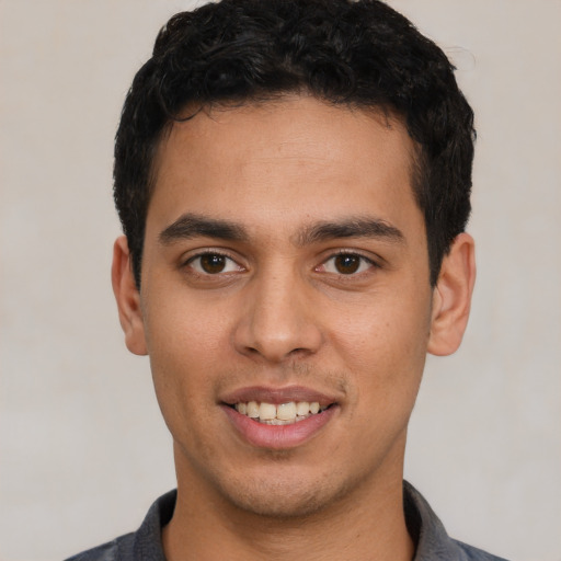 Joyful white young-adult male with short  black hair and brown eyes