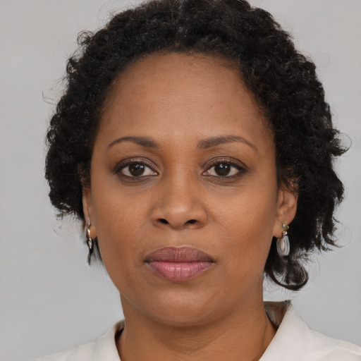 Joyful black adult female with medium  brown hair and brown eyes