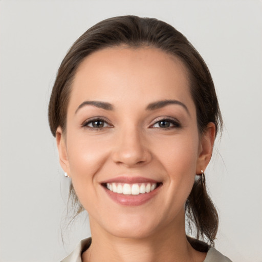 Joyful white young-adult female with medium  brown hair and grey eyes